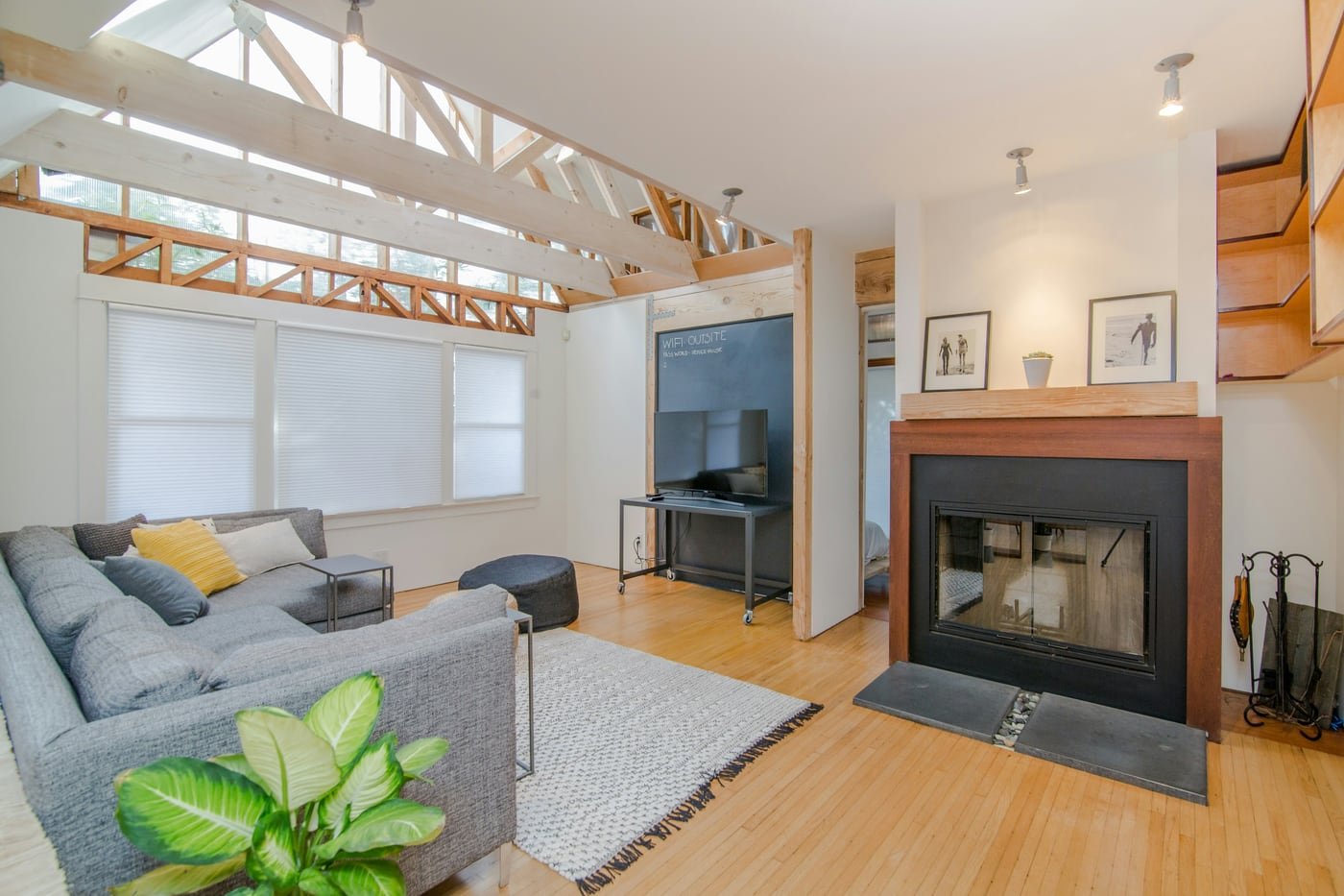 Light-filled home addition with exposed roof framing, living area, and fireplace